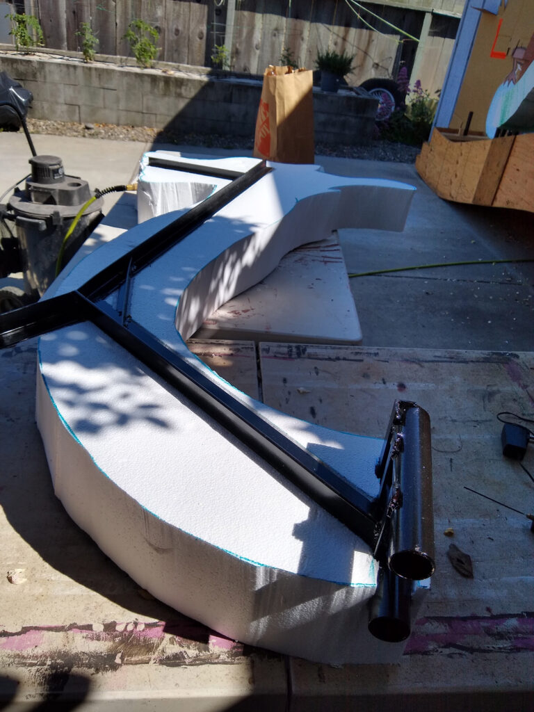 Fitting the armature (that will support the completed dragon) to the foam.
