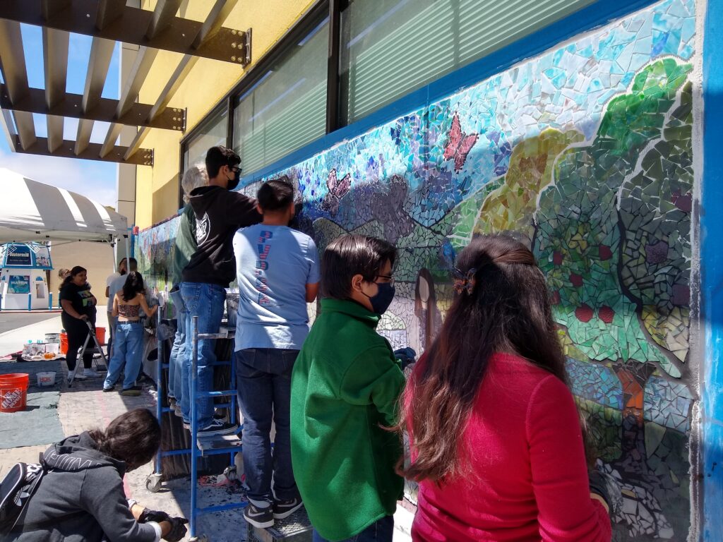 Youth volunteers grouting the new mural at the PVPSA building in Watsonville.